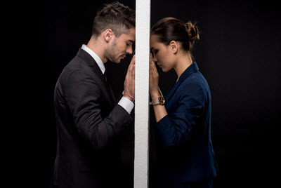 Photo of a couple with their heads leaning against a door separating them. Is your partner wanting to separate but you're not? With discernment counseling in Georgia you can discover if your relationship can be saved.