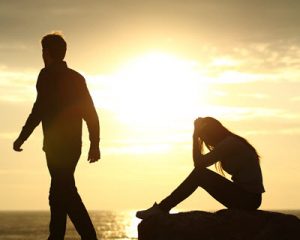 Photo of a couple sitting by the beach looking upset. Are you and your partner struggling with voicing your concerns? With emotionally focused therapy in Georgia you can express your emotions in a new way.