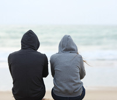 Photo of two people sitting on the beach looking toward the water on a gloomy day. Are you struggling with your relationship? Learn how eft therapy in Georgia can help you create a healthier bond with your partner. Click here to learn more!