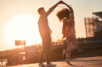 Photo of a man happily spinning a woman during sunset. This photo represents how couples therapy in Georgia can help you repair damaged relationships due to compulsive sexual behavior. Learn more here!