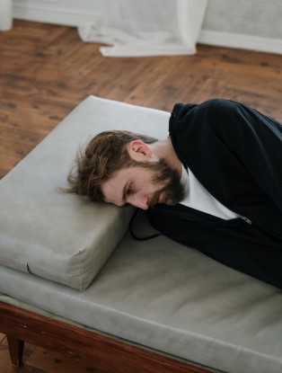 Photo of a man laying down looking sad. Struggling with romantic relationships? Learn how therapy for enmeshed men in Georgia can help you learn how to create healthy boundaries with family so you can have healthier romantic relationships. Click here to learn more!