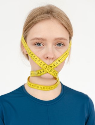 Woman with measuring tape around face. Are you experiencing body image issues? You are not alone, many people have low self esteem and internalized self hatred due to unrealistic media standards. Start body positive therapy to begin accepting ourselves as we are Begin mage therapy in Georgia and get the support you deserve!