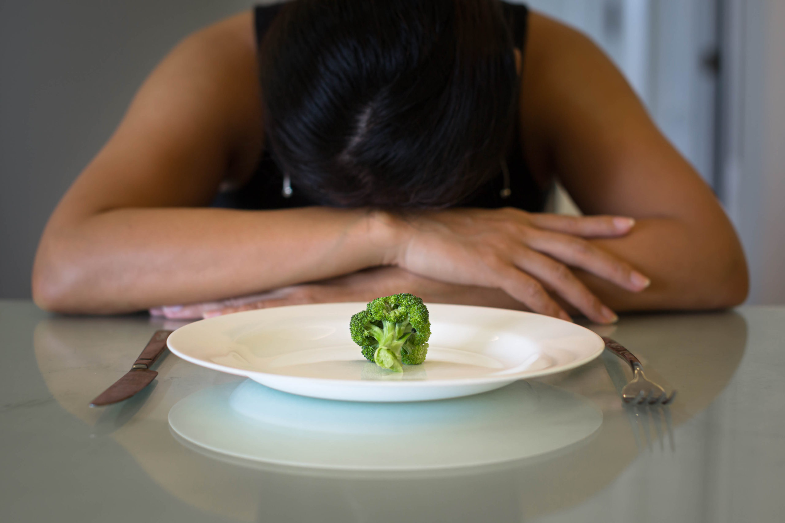 Depressed woman hungry from dieting, sitting in front of a empty plate. Weight loss diet. Its time for a change from the guilt and shame of disordered eating. An eating disorder therapist in East Cobb, GA can help. Learn about how bulimia nervosa treatment in East Cobb, GA or bulimia Nervosa treatment in Marietta can support you today!