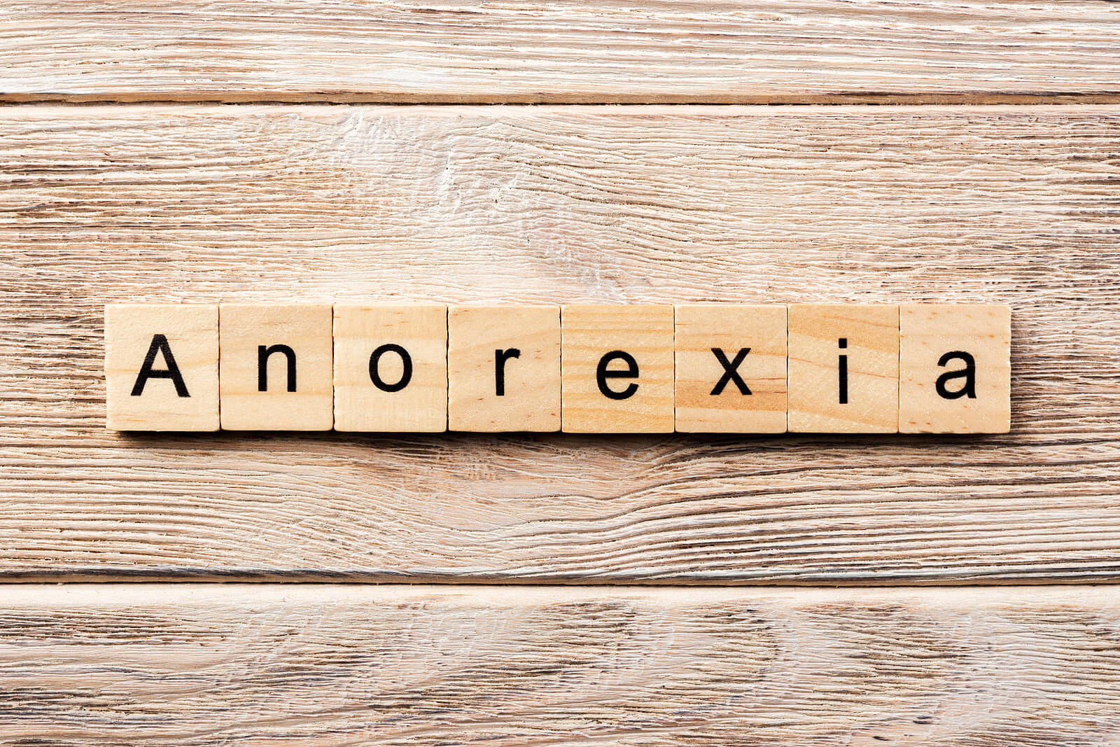 Photo of wooden letters spelling out the word anorexia. Are you or a loved one struggling with anorexia nervosa? Learn how anorexia nervosa treatment in Georgia can help provide you with support.