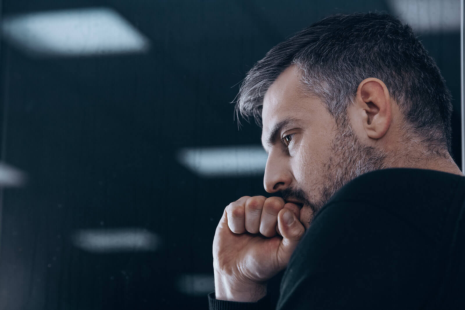 Photo of a man sitting with his hand on his chin looking like he is in thought. Struggling with bad behaviors? With dbt therapy in Georgia you can learn the skills to control unwanted behaviors.