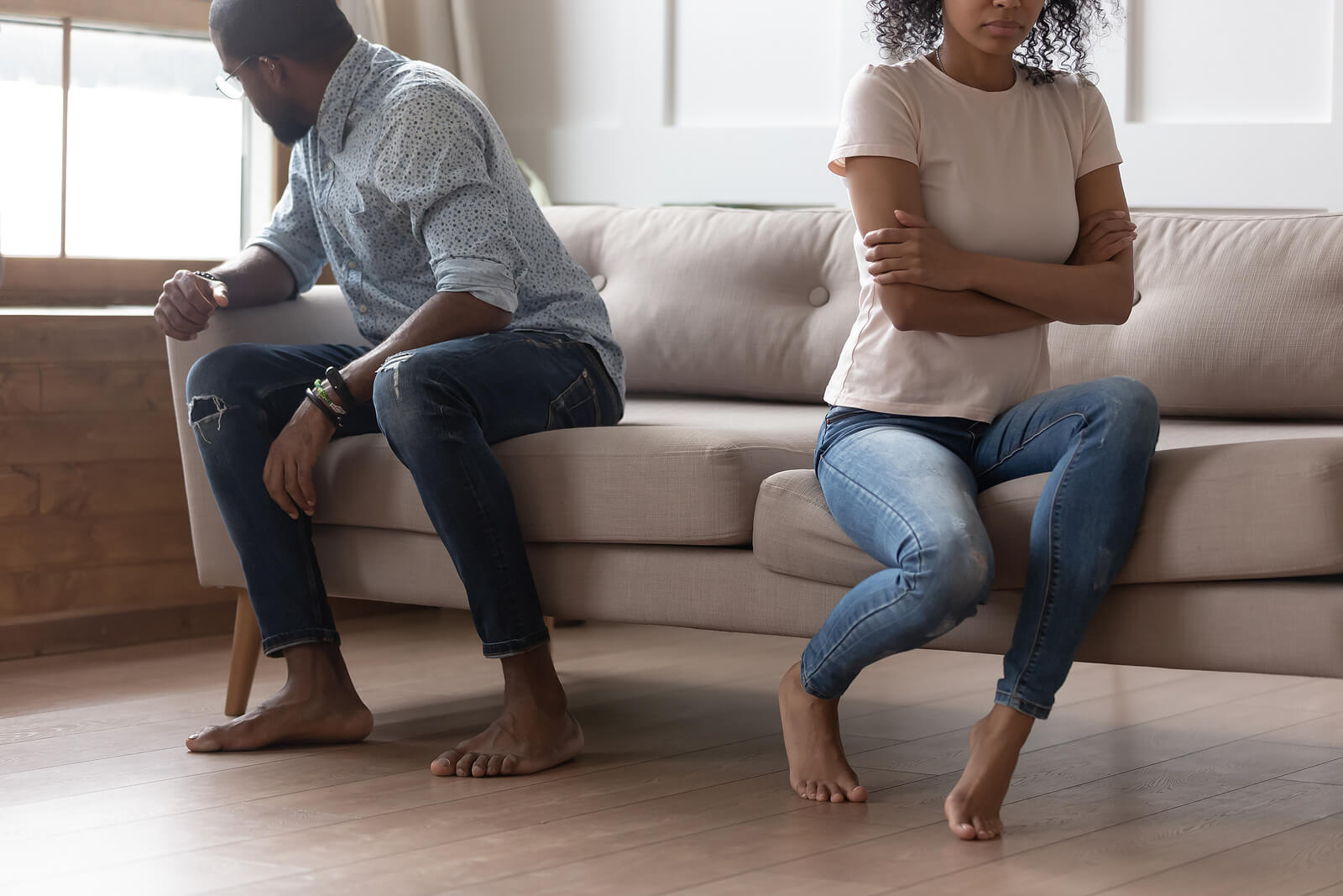 Photo of a black couple sitting on a couch angrily facing away from each other. Is sexual addiction causing problems in your relationship? Meet with a skilled therapist to start sexual addiction therapy in Georgia to help repair your relationship with your partner.